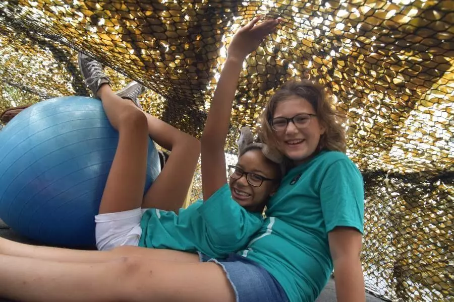 Two elementary school students on a playground smile at the viewer.