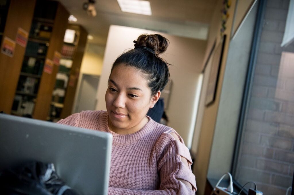 A student works at a laptop computer.